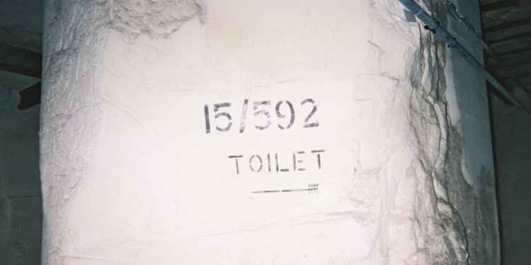 A painted sign pointing to toilets in District 15.