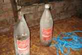 Two vintage Coca Cola bottles sit in an underground government office.